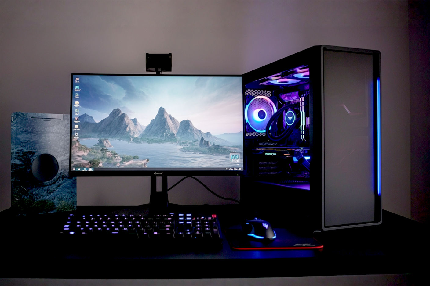 Professional photography style image showing a sleek, modern, but not overly flashy gaming PC setup. The PC case is visible with subtle or no RGB lighting, positioned next to a monitor displaying a vibrant game scene. A keyboard and mouse are also in the foreground. The overall feel is clean, accessible, and inviting to new gamers.